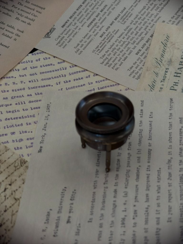 Chart magnifier set over archival documents and technical notes