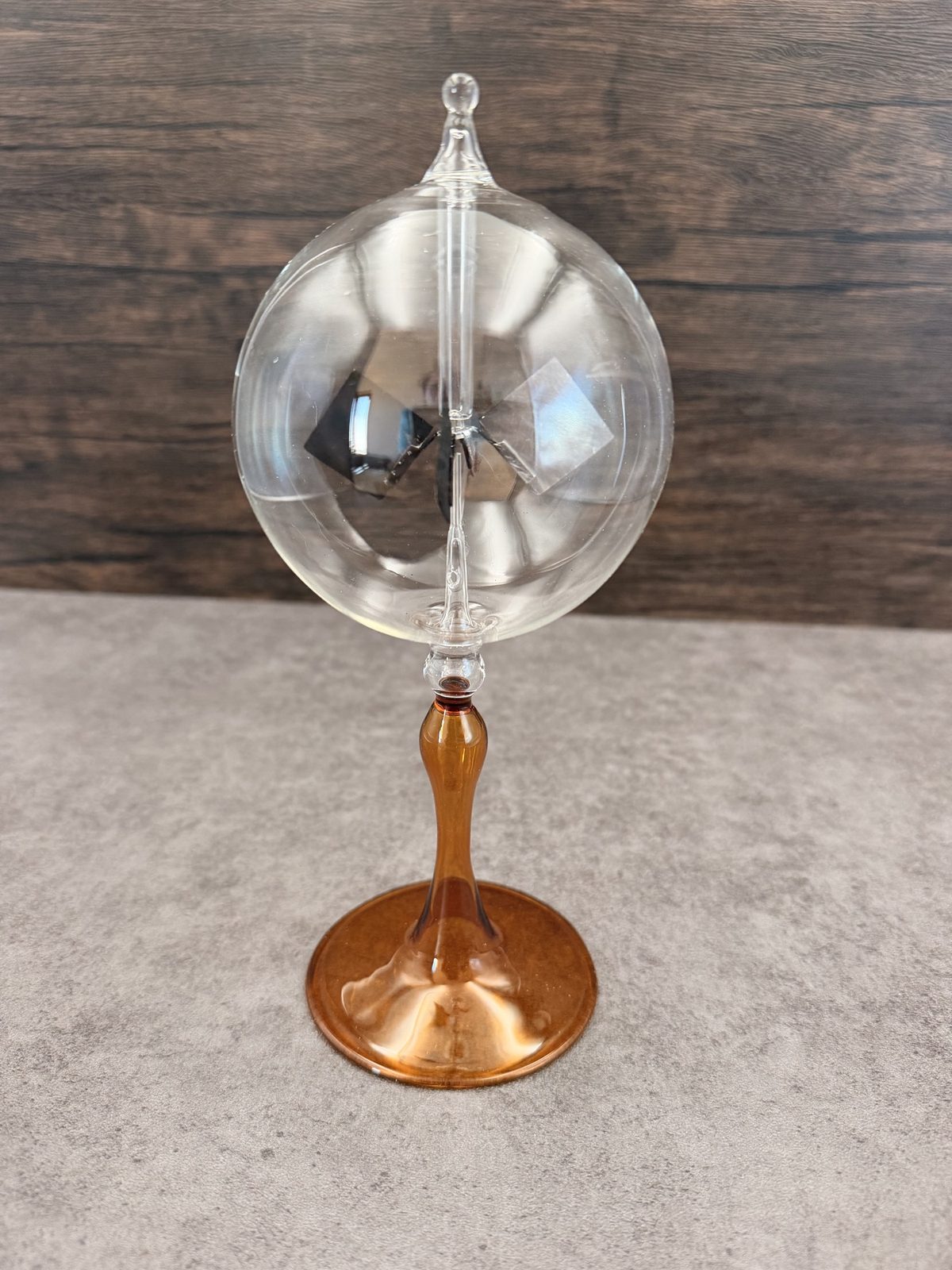 Glass Crookes radiometer with reflective vanes and an amber base